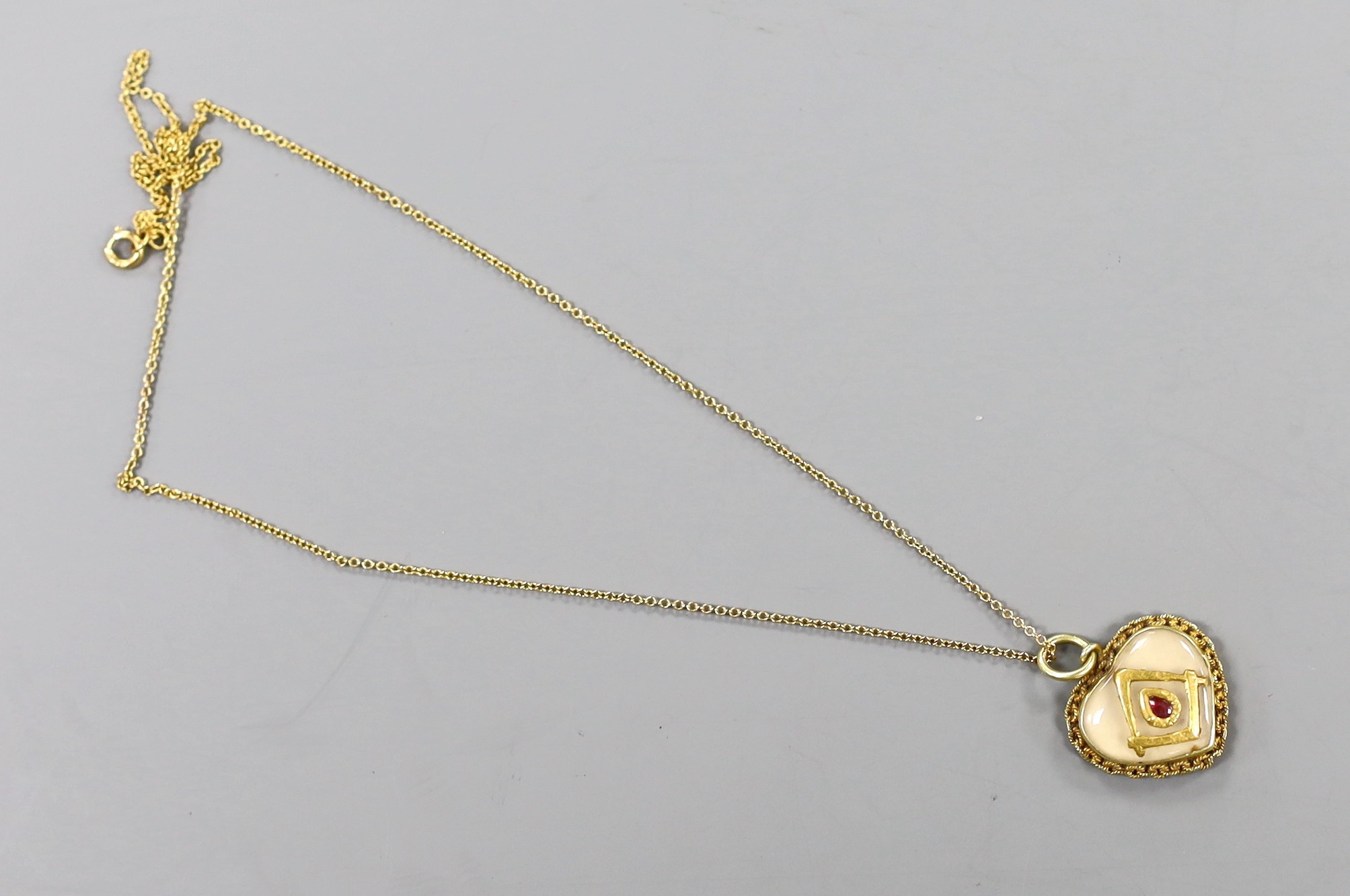 A yellow metal and cabochon gem set heart shaped masonic pendant, 16mm, on a 9ct chain, gross 4 grams.